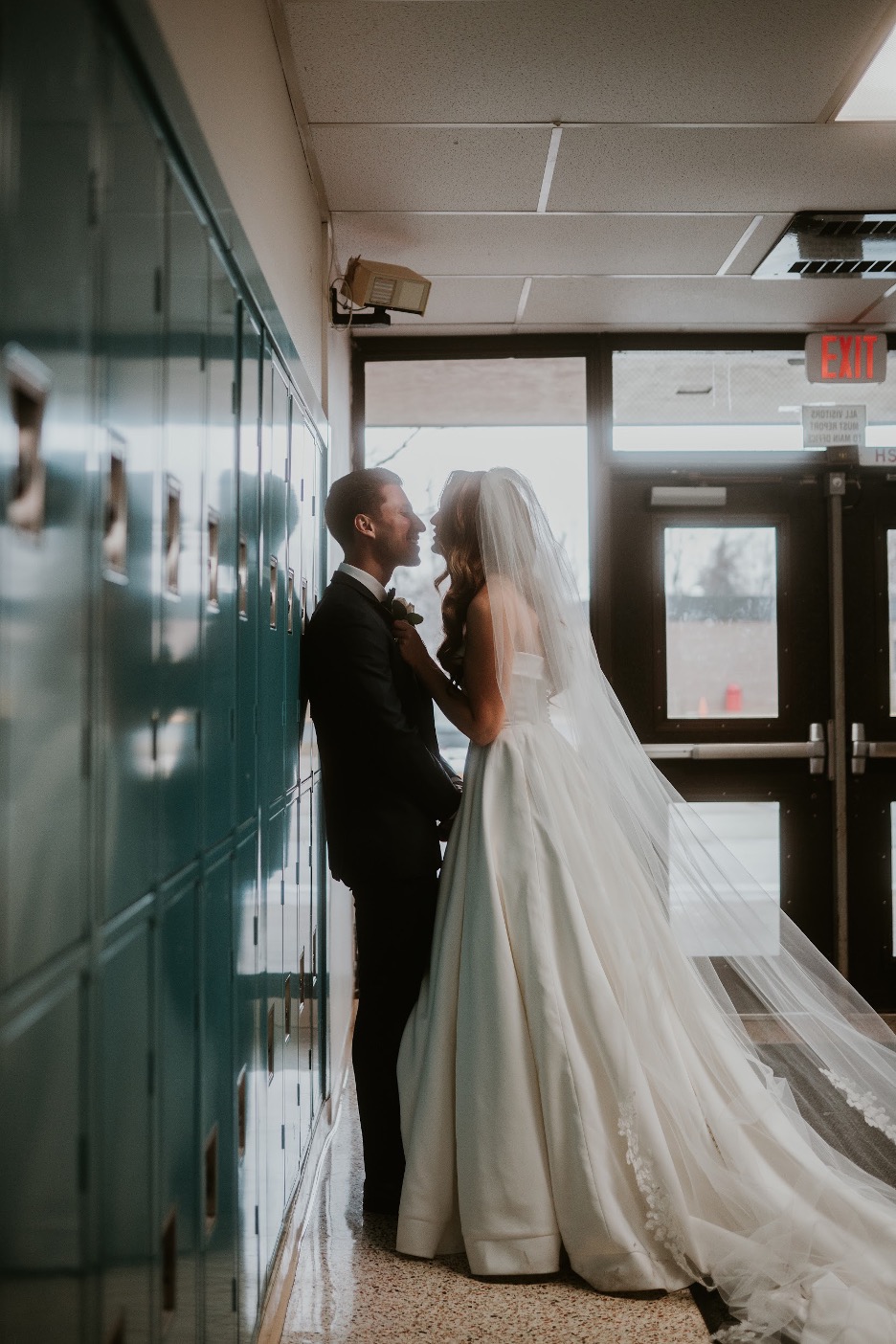 The bride and groom make a pitstop at their high school, where they met, on their wedding day.